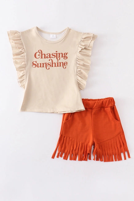 2pc little girl short set, cream top with ruffle sleeve "chasing sunshine" paired with suede brown fringe shorts