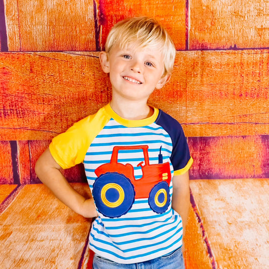 Striped tee with blue and yellow sleeves and red tractor on the front
